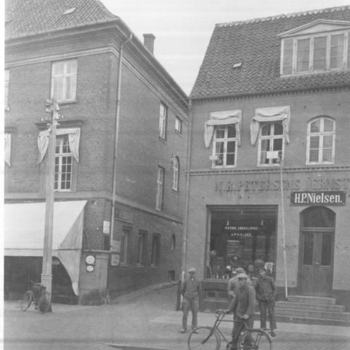 Sort-hvid foto af to bygninger med en smøge imellem.