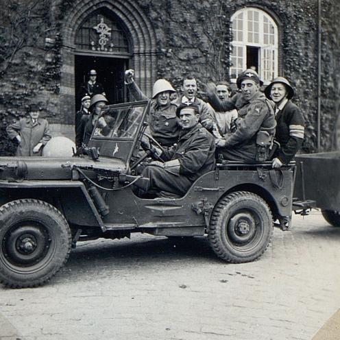 Sort-hvid foto af en jeep fyldt med soldater foran Holbæk Rådhus.